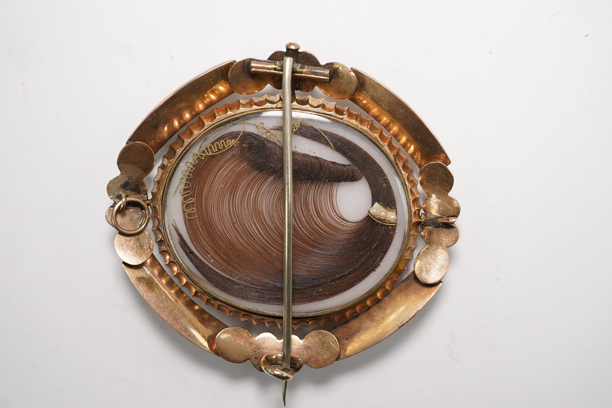 A cased Victorian yellow metal and plaited hair sey oval mourning brooch, 59mm. Condition - fair
